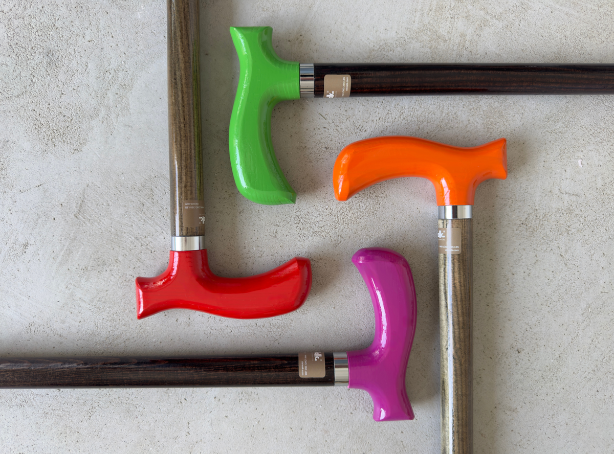Close-up of the DaiWalk anatomic cane handle and steel collar on a wooden shaft