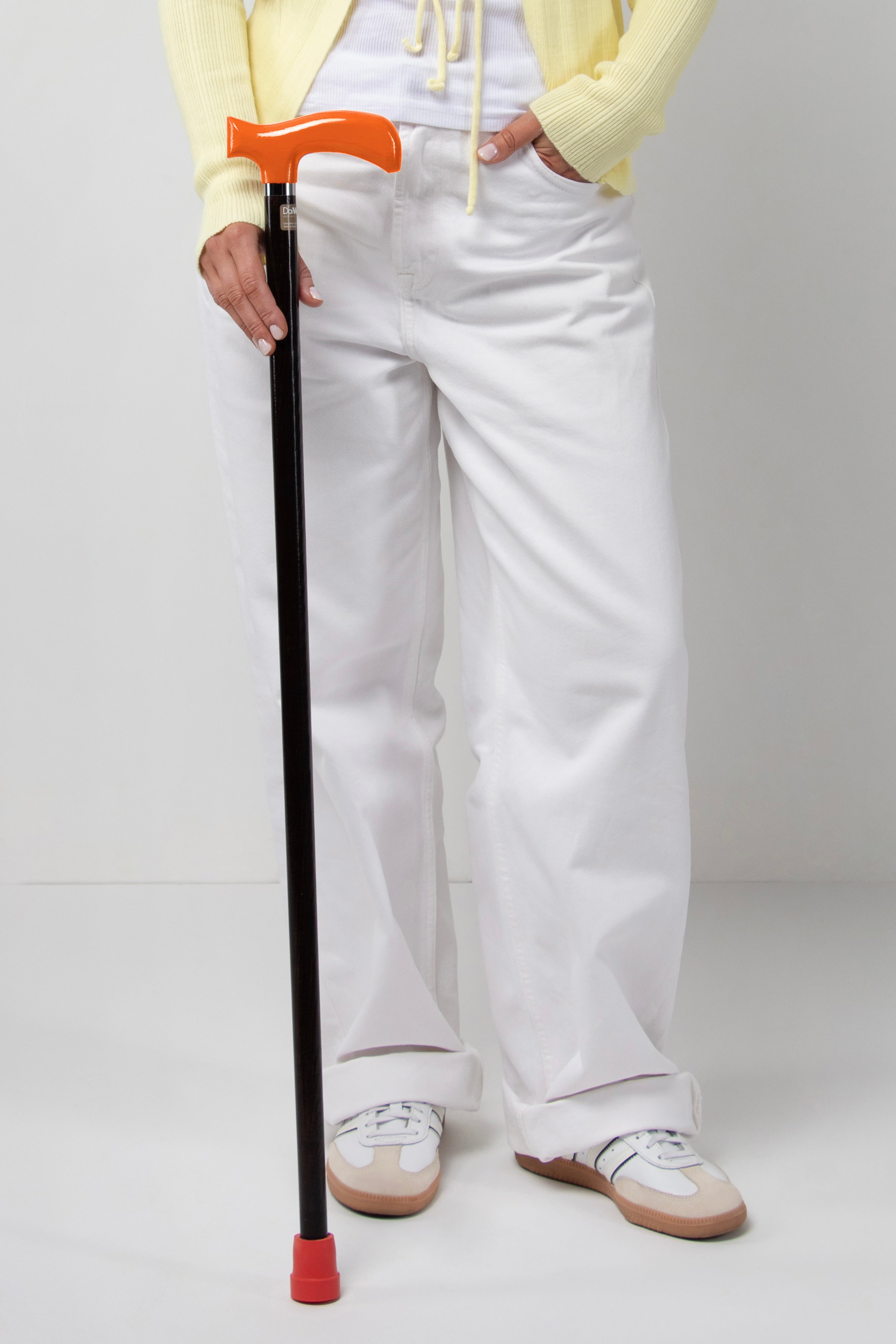 Bold orange handle walking stick on dark walnut oak wood for women's posture. Premium tailored cane for active women's daily use.