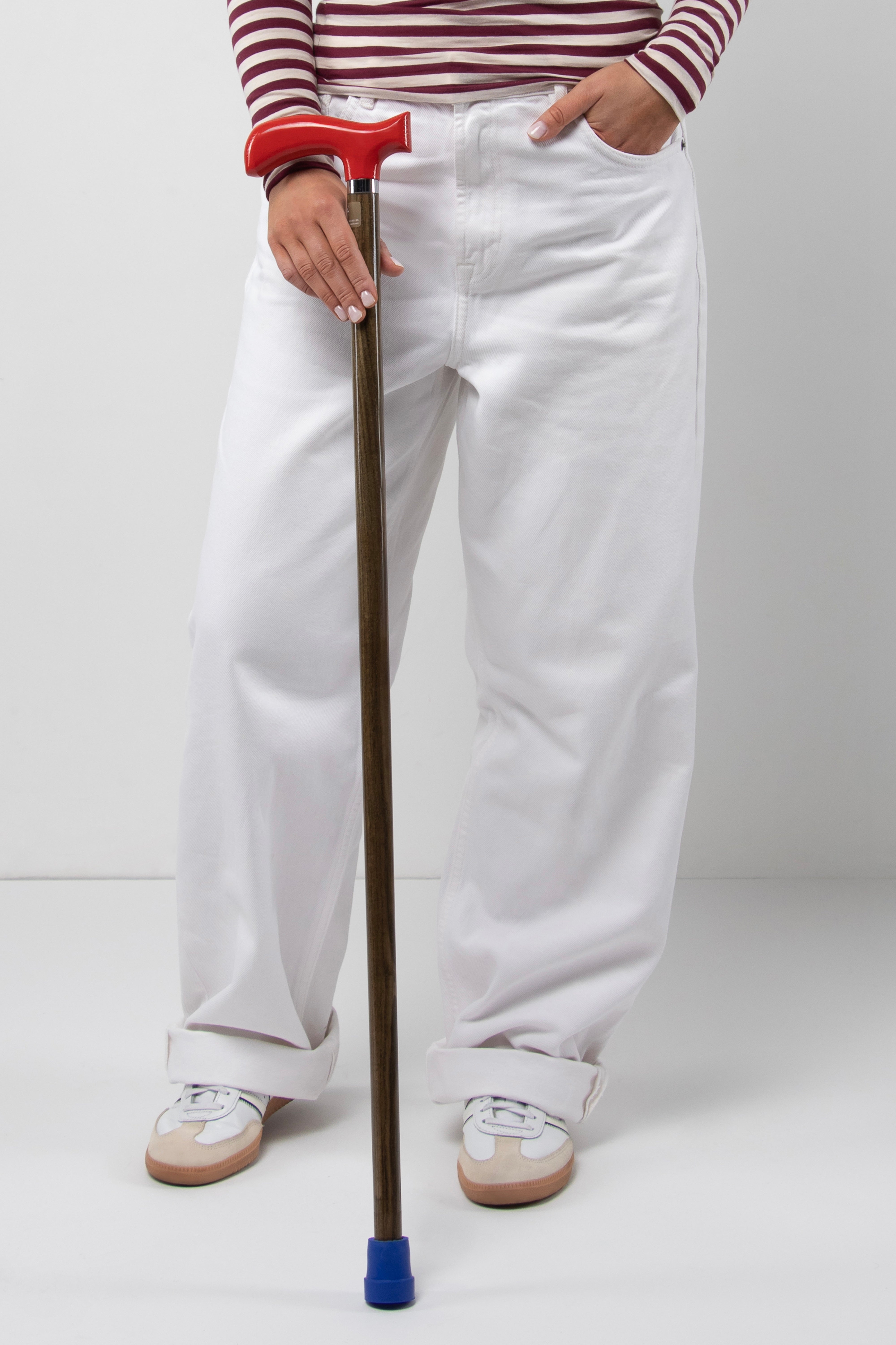 Classic elegant young woman's walking cane with dark red handle on light oak wood shaft. Custom made mobility tool for perfect posture.