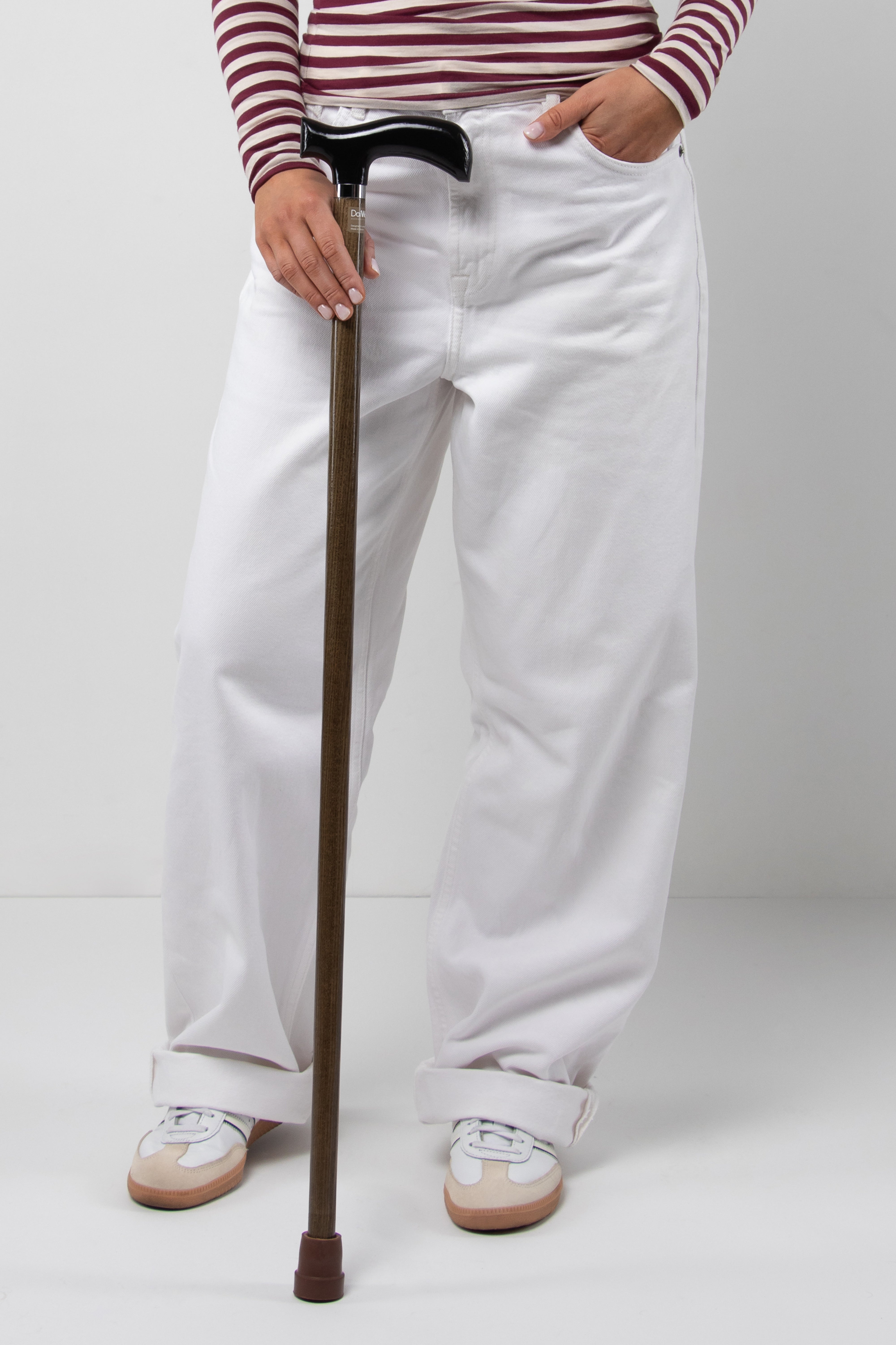 Minimalist young woman's all-black walking cane with light natural oak wood shaft. Stylish custom length aid for perfect women's comfort.