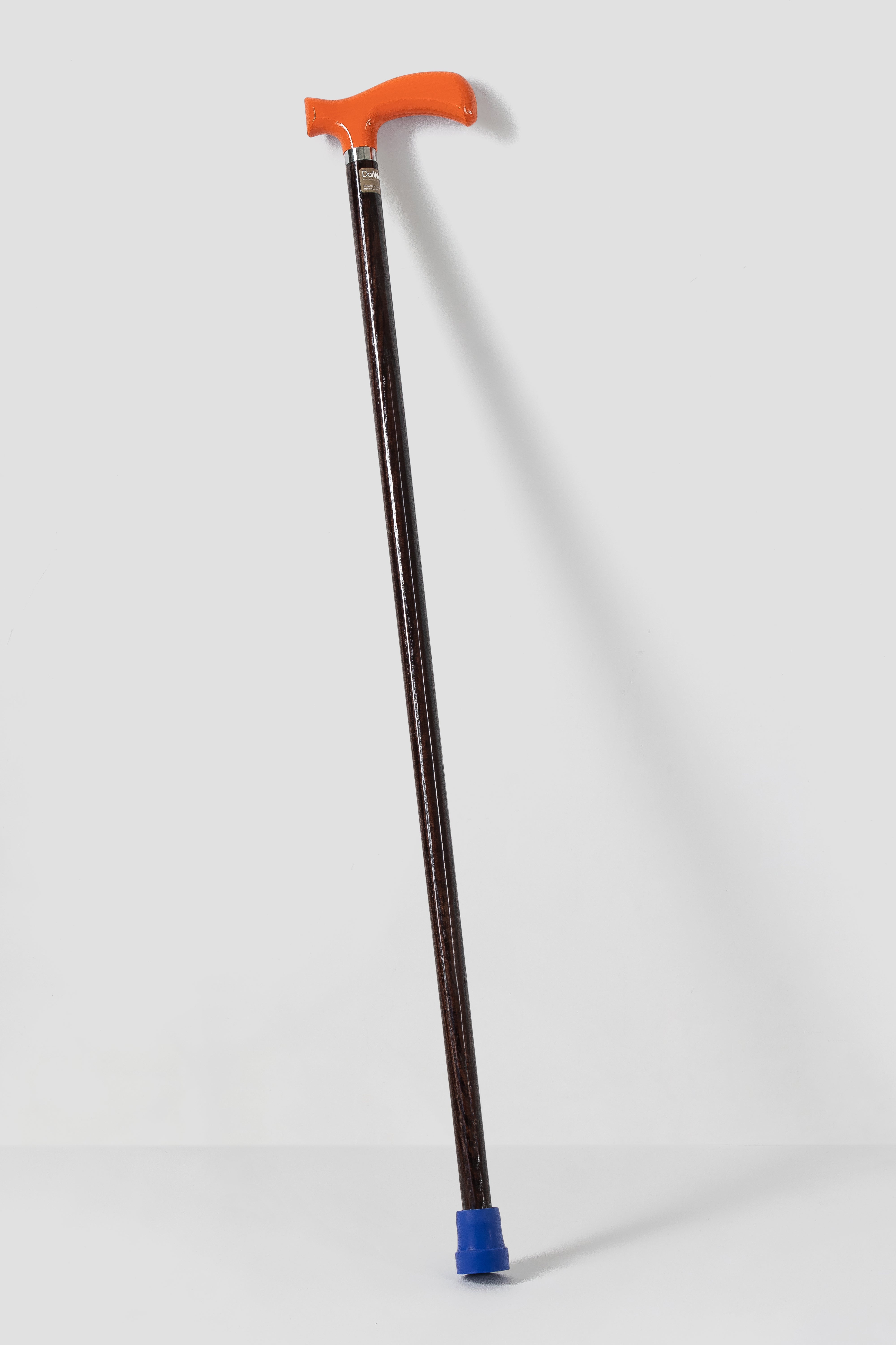 Orange luxury walking cane on light natural oak. Mint green designer mobility aid for modern aesthetics.