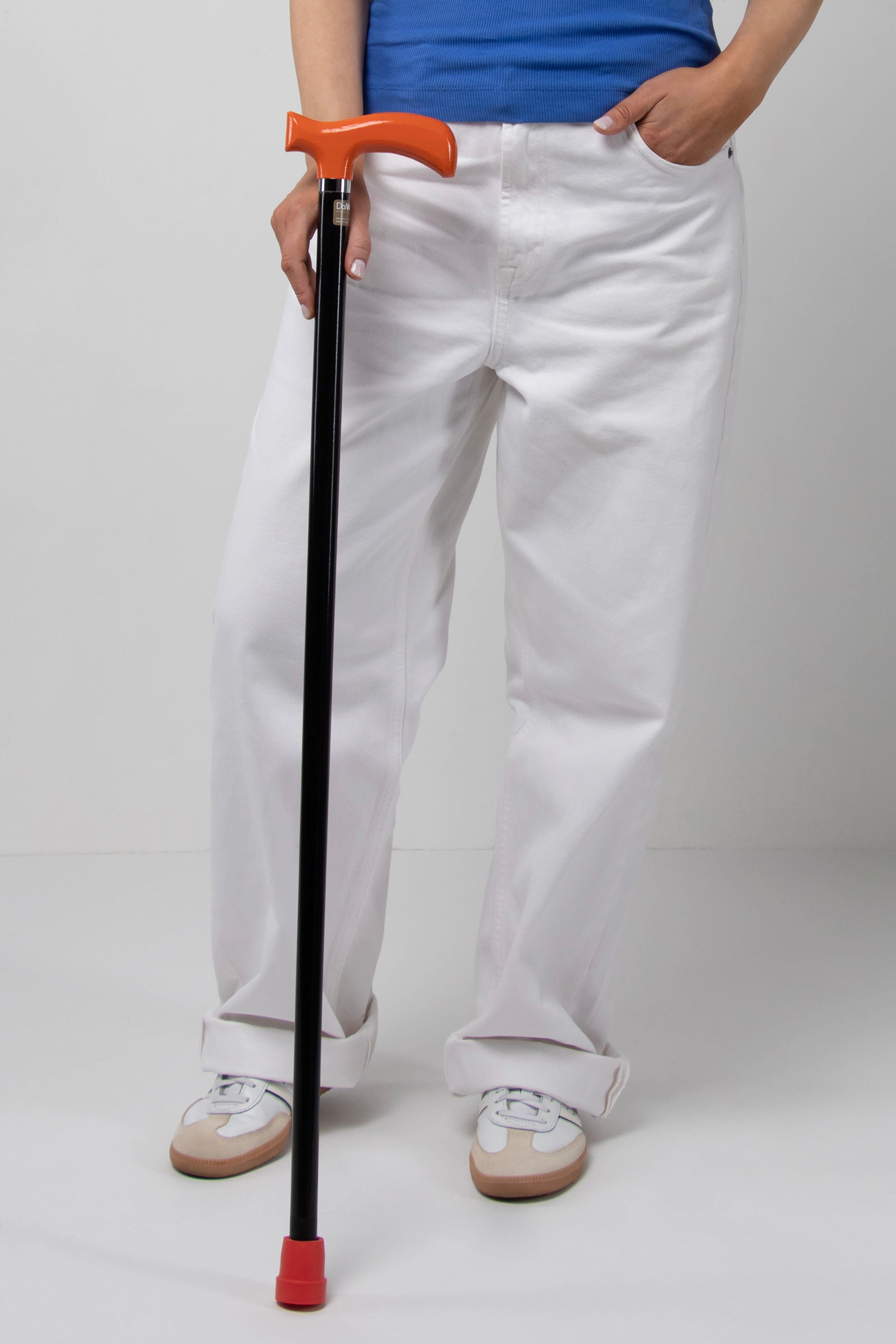 Sleek orange handle walking cane with minimalist black shaft for modern women's style. A high-value mobility accessory with silent performance.
