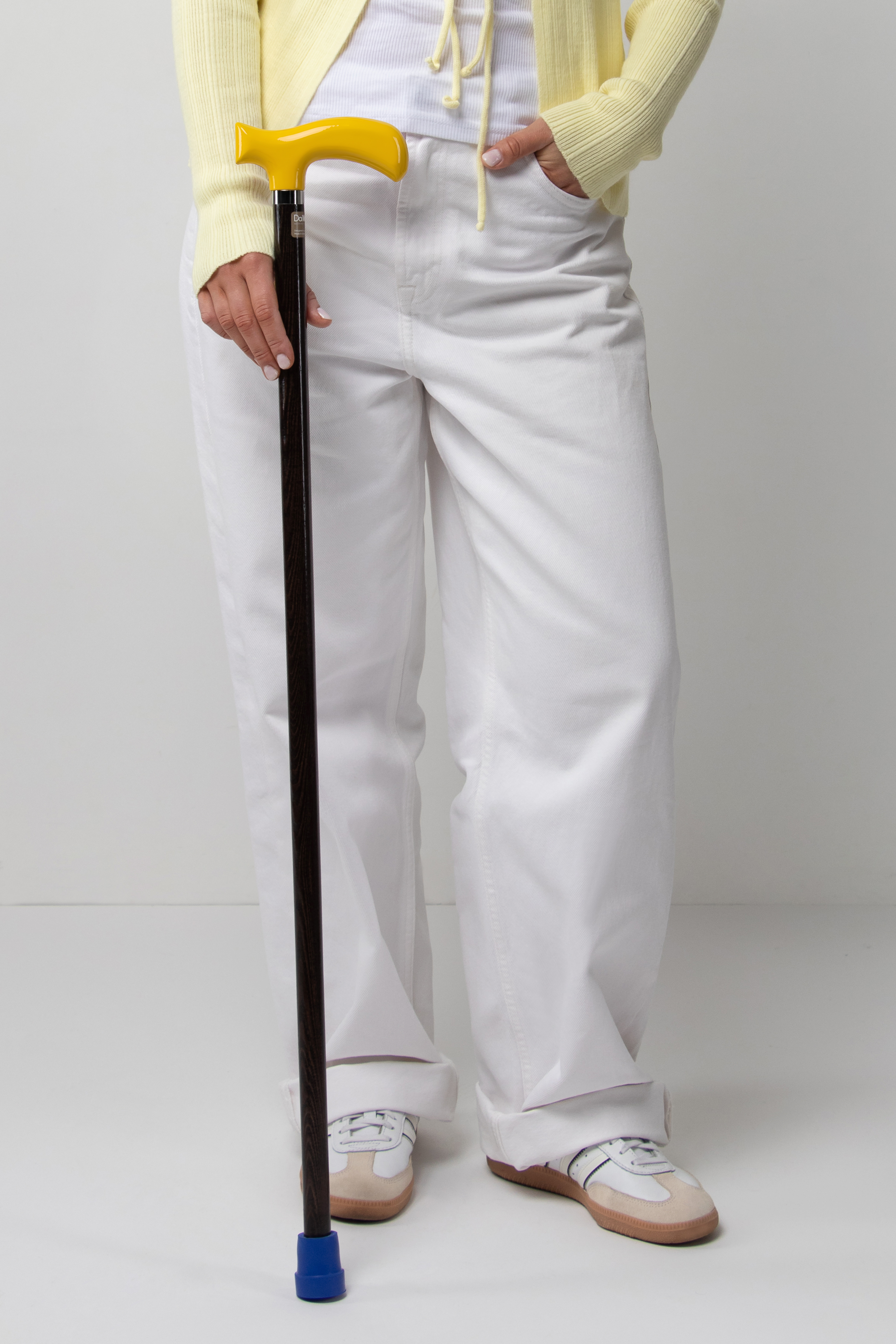 Trendy women's walking stick with vibrant yellow handle on dark stained oak. A bold accessory for fashion-forward women's outfits.