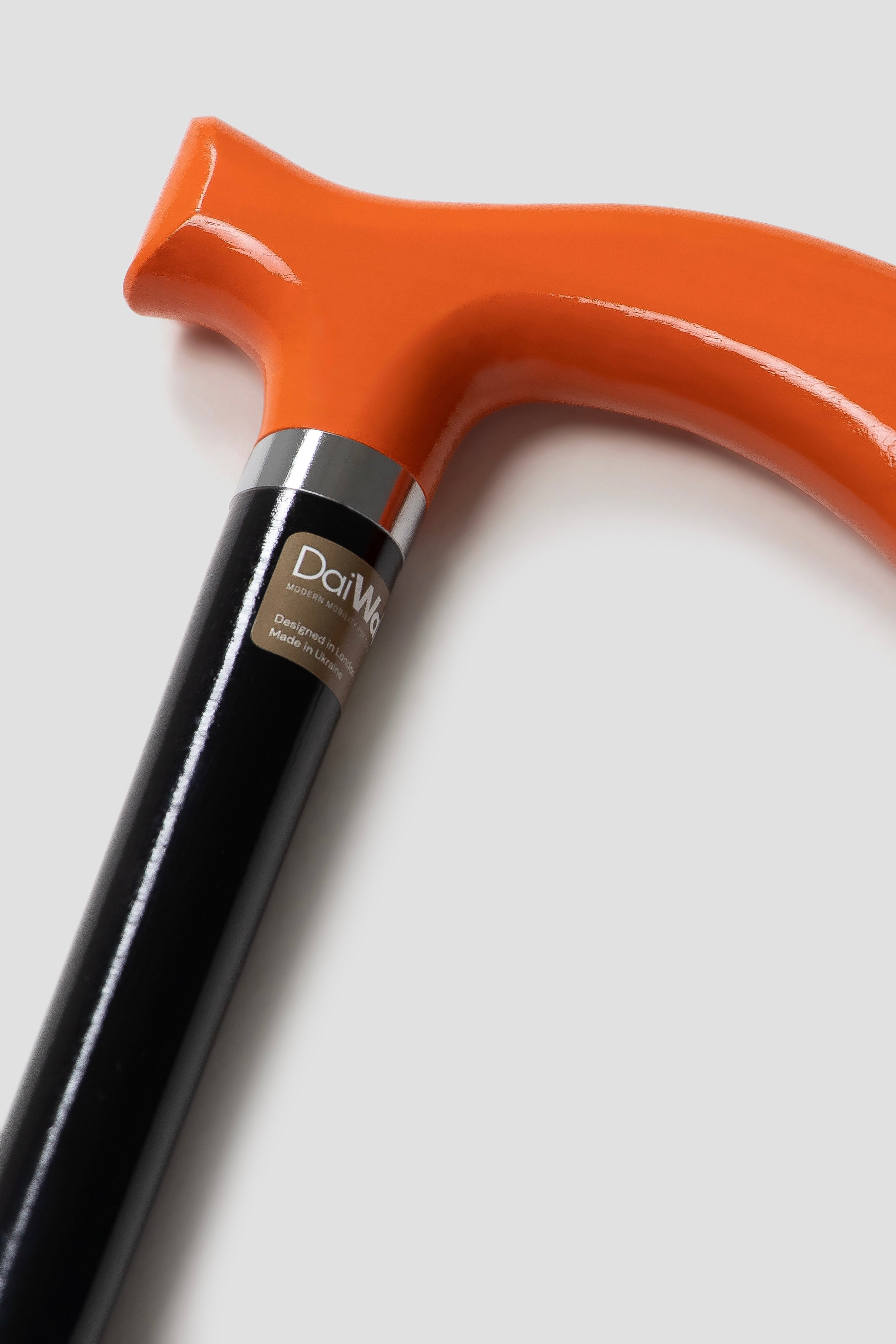 Industrial style orange handle walking cane with solid black shaft for men. Modern ergonomic aid with non-slip rubber tip.