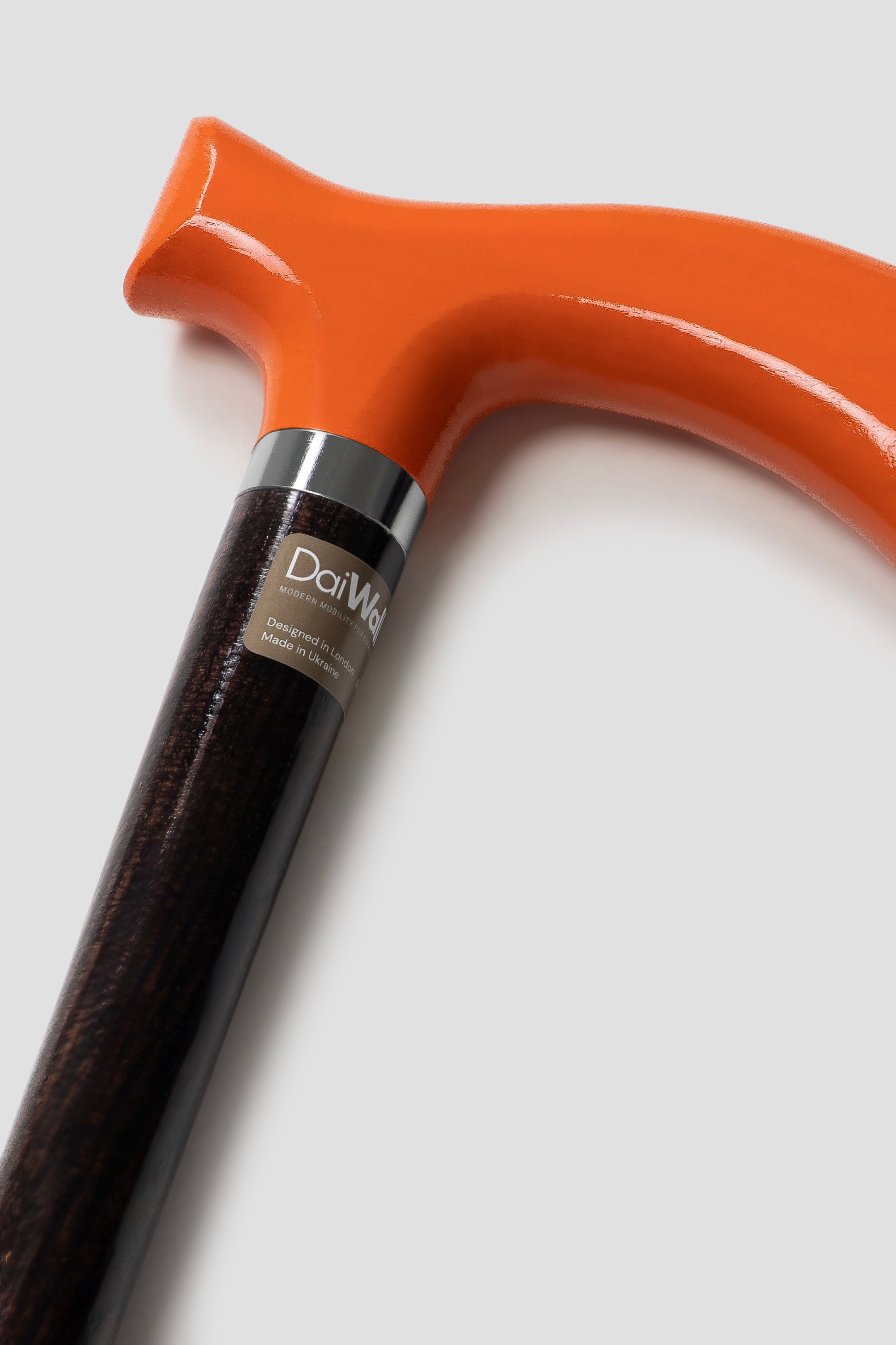 Bold orange handle walking stick on dark oak shaft for men. Premium tailored cane for stable and silent posture support.