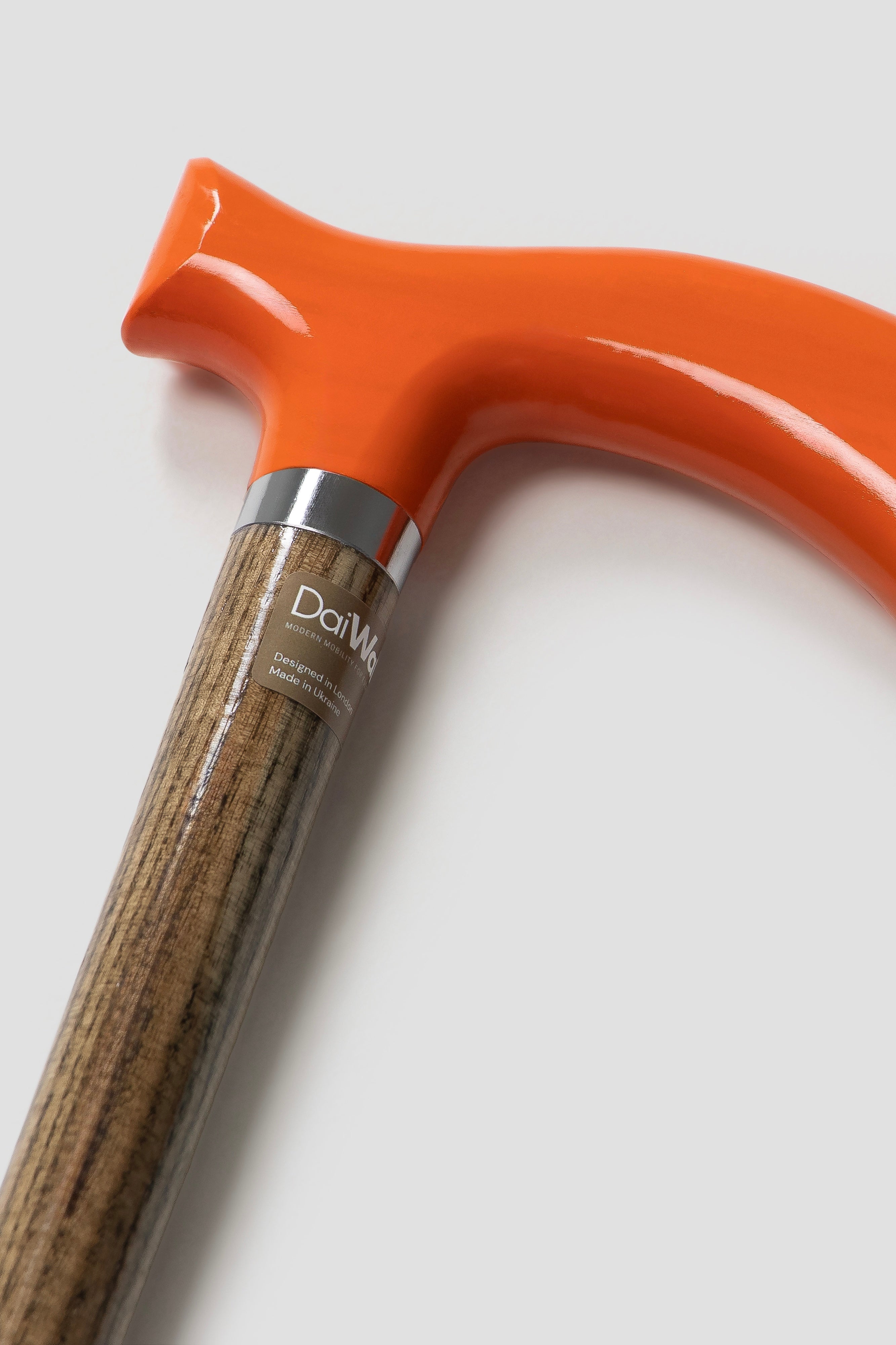 Bright orange handle walking cane for men with light natural oak wood. High-performance designer mobility aid for active lifestyle.