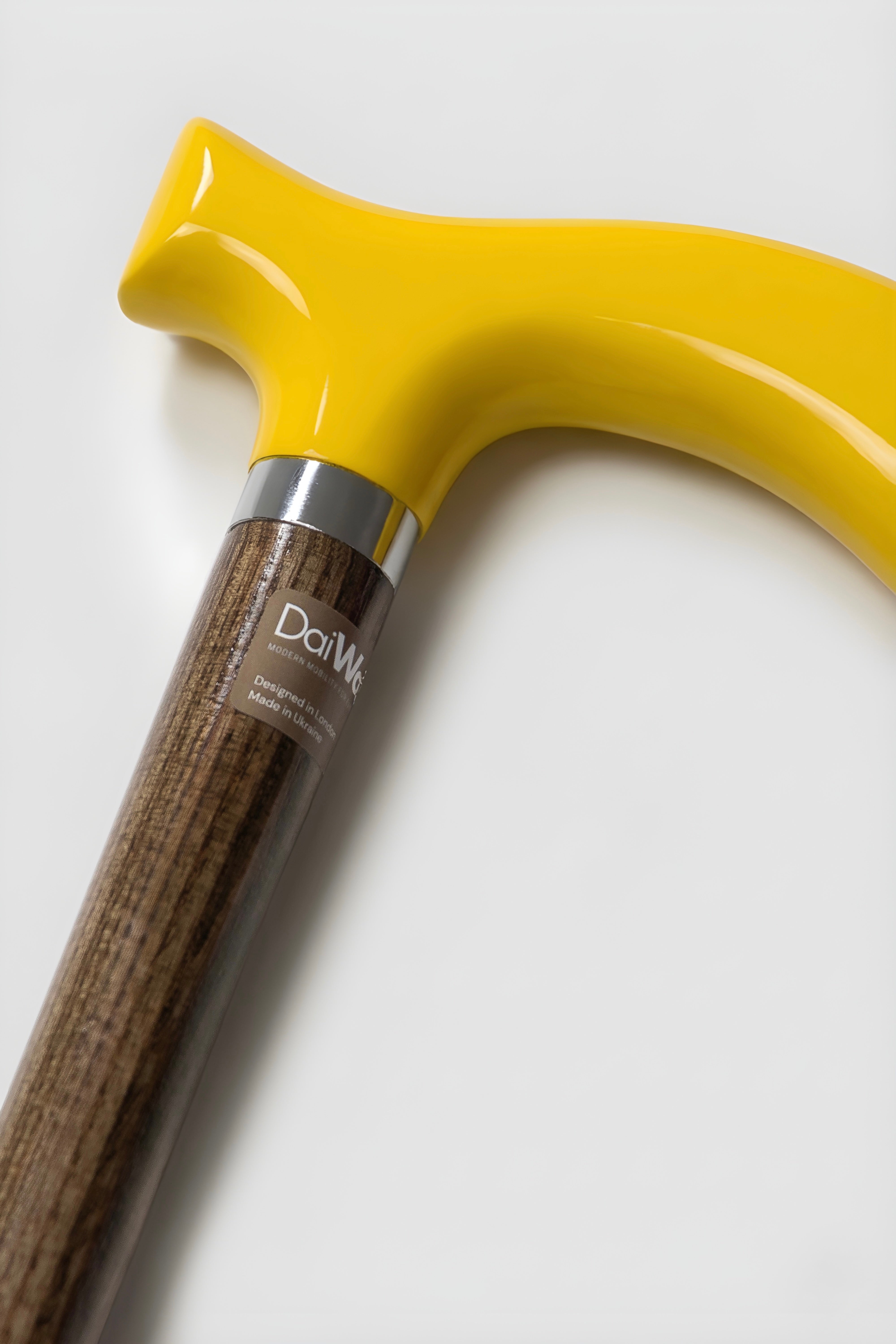 Men’s yellow handle walking cane with light oak shaft. High-visibility designer mobility aid for confident urban stride.